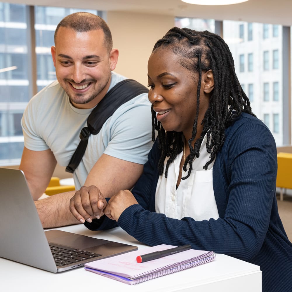Two students working together using laptop