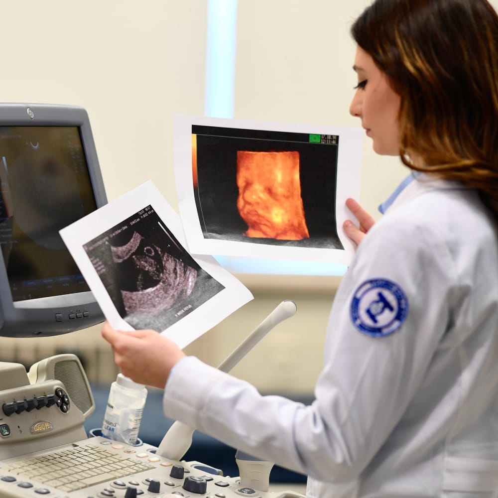Student looking at ultrasound photos next to equipment