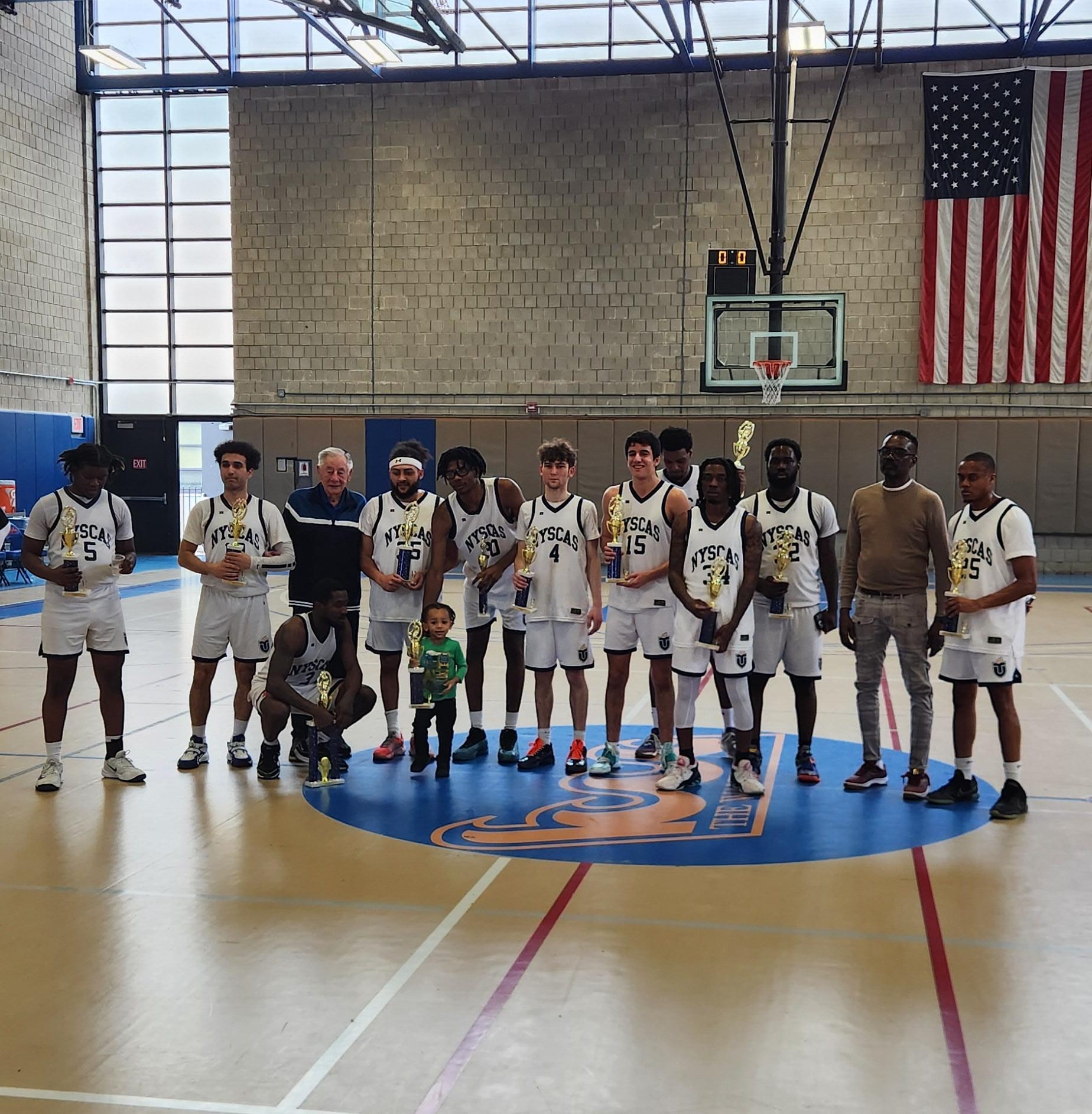 The Touro Tornadoes basketball team lines up after winning the Touro University Invitational tournament.